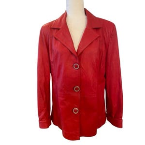 May include: A red leather jacket with a collared neckline and button closure. The jacket has a fitted silhouette and long sleeves.
