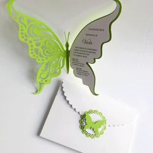 Puede incluir: Una mariposa de papel verde recortada sobre un fondo blanco. La mariposa est&aacute; doblada para crear un efecto 3D. El texto en el fondo dice "5 MAGGIO 2019 Battesimo di Viola Sono felice di condividere questo momento speciale con le persone che mi vogliono bene. Parrocchia SAN NICOLA DI BAR Castellano Lagurello ore 11:30  Locale SERENITA' Localita' Venturini, 44  Villaggio sul Mincio"