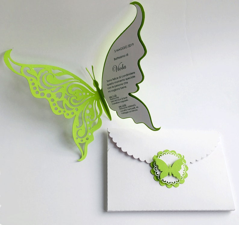 Puede incluir: Una mariposa de papel verde con un dise&ntilde;o recortado est&aacute; unida a una tarjeta blanca con el texto "5 MAGGIO 2019 Battesimo di Viola Sono felice di condividere questo momento speciale con le persone che mi vogliono bene. 11:20 Parocchia SAN NICOLA DI BARI ColorLagels YOHDEC Nico" impreso en ella.