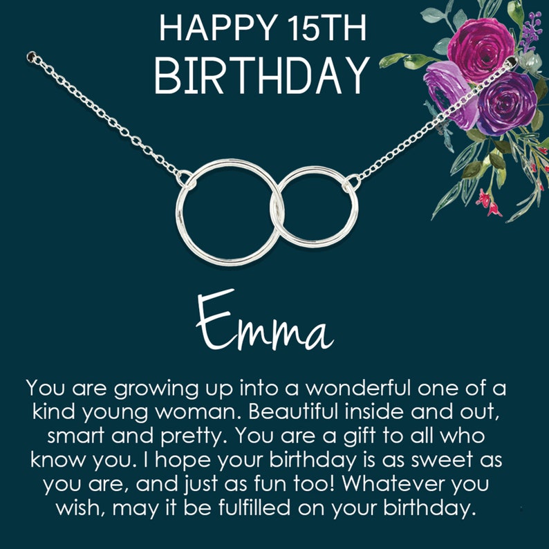 May include: A silver necklace with two interlocking circles, a birthday card with the text "HAPPY 15TH BIRTHDAY Emma" and a floral design in the background. The card reads "You are growing up into a wonderful one of a kind young woman. Beautiful inside and out, smart and pretty. You are a gift to all who know you. I hope your birthday is as sweet as you are, and just as fun too! Whatever you wish, may it be fulfilled on your birthday."