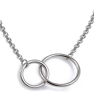 May include: A silver chain necklace with a double circle pendant.