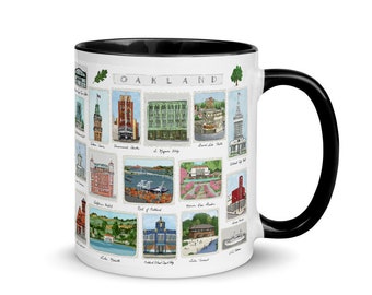 May include: A white ceramic mug with a black handle and interior rim, featuring a colorful illustrated grid of Oakland landmarks and the text OAKLAND at the top. Each individual illustration is framed like a postage stamp with labels below.