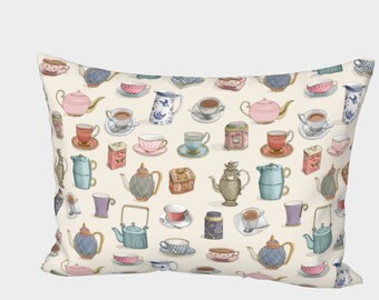 May include: A cream-colored pillow with a repeating pattern of teapots and teacups in various colors and styles. The pattern includes blue, pink, green, and brown teapots and cups.