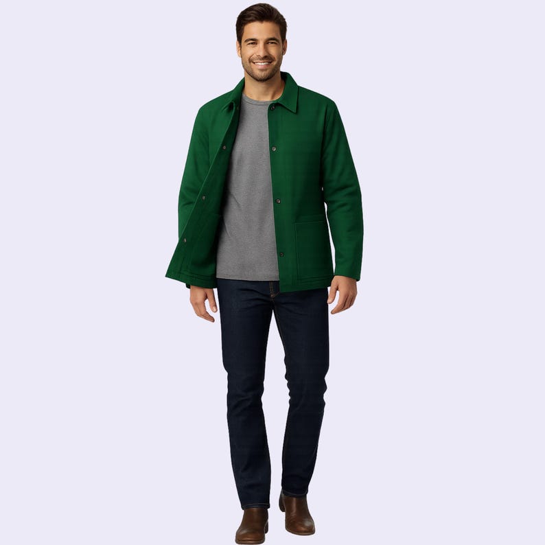 May include: A person wearing a green jacket, gray t-shirt, and dark blue jeans. The jacket has a button-up front and two front pockets. The person is also wearing brown boots.