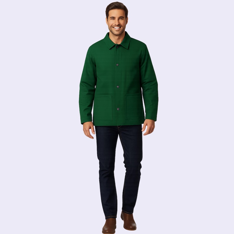 May include: A green jacket with a button-up front and two front pockets. The jacket is paired with dark blue jeans and brown boots. The person is smiling.