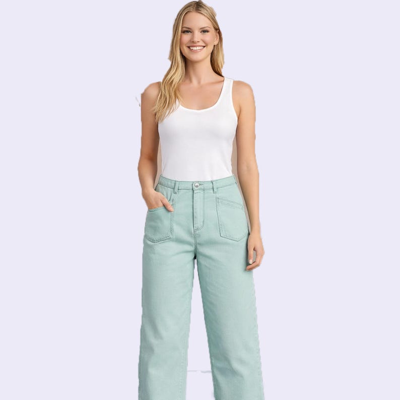 Puede incluir: Una camiseta sin mangas blanca con cuello redondo combinada con pantalones vaqueros anchos de color verde menta claro, con cintura alta, cierre de bot&oacute;n y cremallera, y dos grandes bolsillos de parche en la parte delantera.