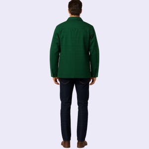 May include: A dark green jacket with a button-down front and long sleeves. The jacket is paired with dark blue jeans and brown shoes. The person is viewed from the back, showcasing the jacket's design and fit.