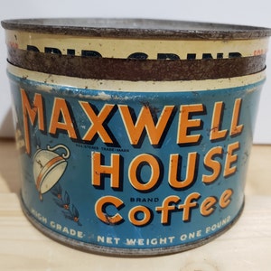 May include: A vintage tin can for Maxwell House coffee. The can is blue with orange lettering and a picture of a coffee pot. The text on the can reads "Maxwell House Brand Coffee, High Grade, Net Weight One Pound."