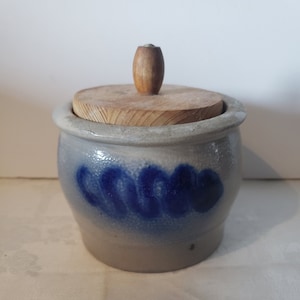 Peut inclure: Un pot en grès gris avec un motif bleu et blanc et un couvercle en bois avec un bouton. Le pot est de style traditionnel et est parfait pour ranger de petits objets.