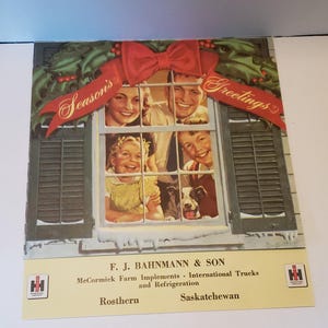 May include: A Christmas card featuring a family of four looking out a window decorated with holly and a red bow. The card reads "Season's Greetings" and includes the company name "F. J. Bahnmann & Son", "McCormick Farm Implements - International Trucks and Refrigeration", "Rosthern", and "Saskatchewan".