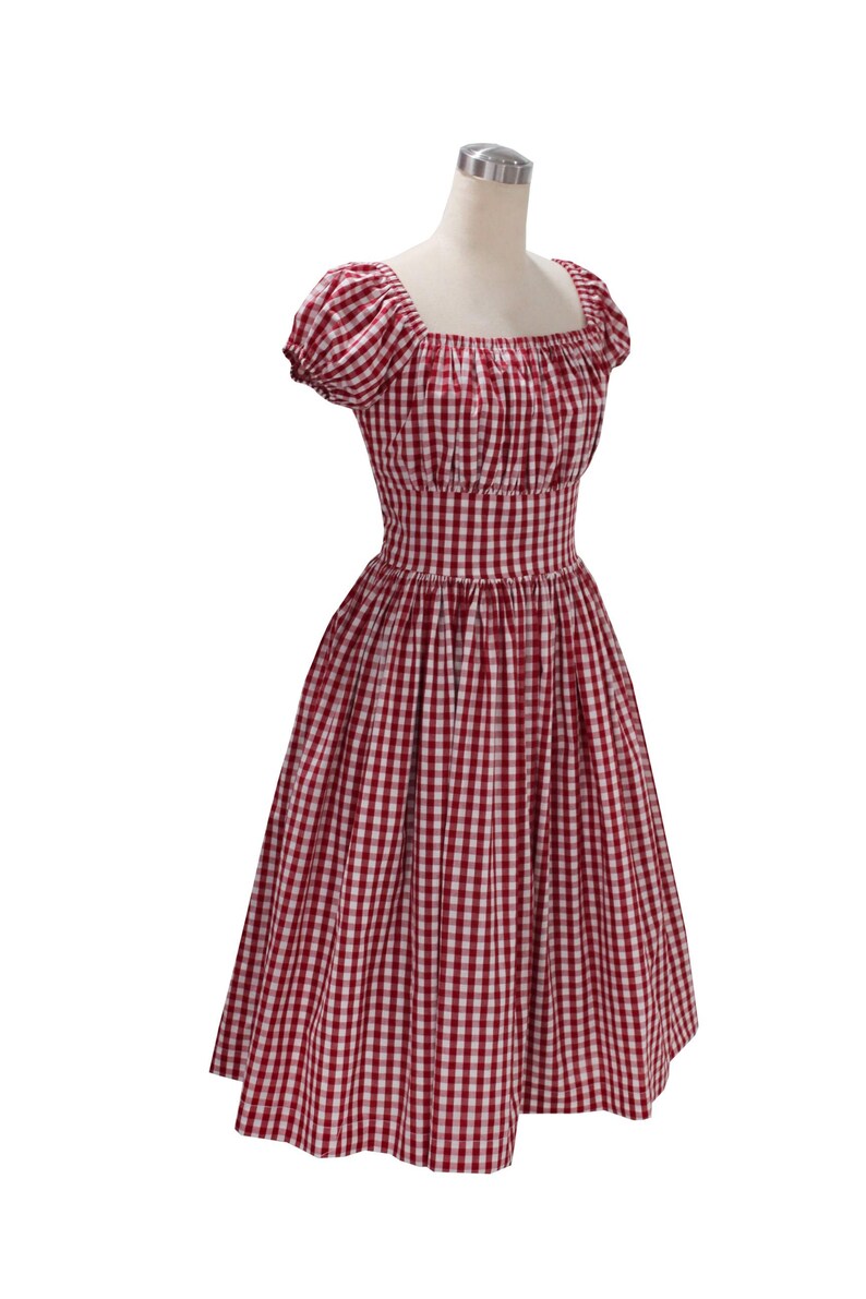 May include: A red and white gingham dress with a square neckline and short, puffed sleeves. The dress has a fitted bodice and a flared skirt, creating a classic, vintage silhouette. The fabric is a classic gingham pattern, perfect for a summer day.