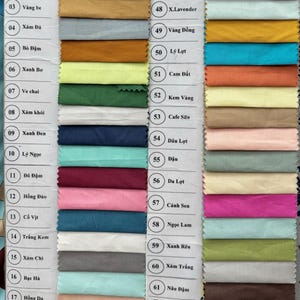 May include: A fabric swatch color chart featuring sixty-four numbered samples arranged in two columns. Each rectangular fabric piece displays a distinct solid color, including various shades of blue, green, red, yellow, pink, brown, gray, and white.