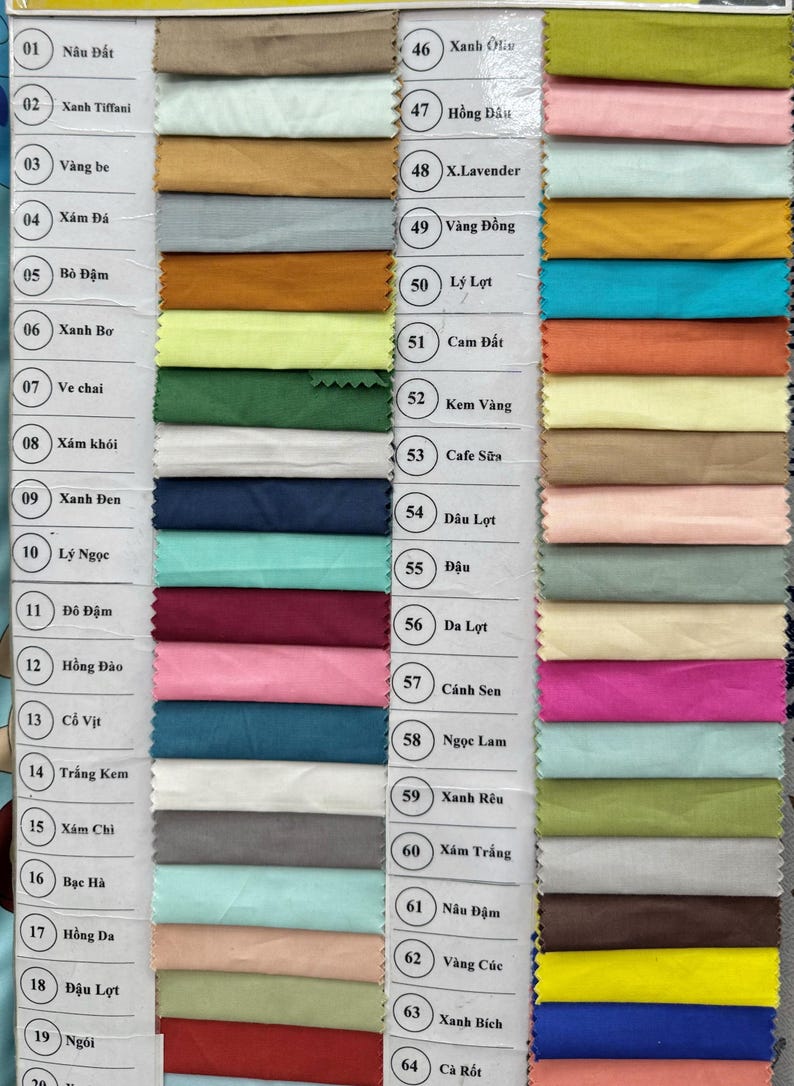 May include: A fabric swatch color chart featuring sixty-four numbered samples arranged in two columns. Each rectangular fabric piece displays a distinct solid color, including various shades of blue, green, red, yellow, pink, brown, gray, and white.