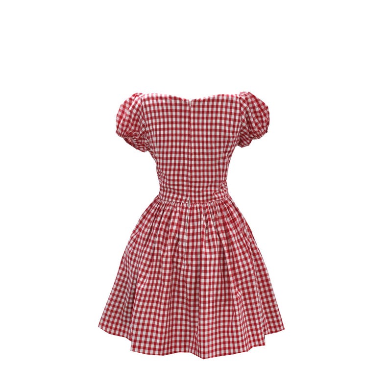 May include: A red and white gingham dress with a fitted bodice and a flared skirt. The dress features short, puffed sleeves and a zipper closure down the back. The fabric has a classic checkered pattern.