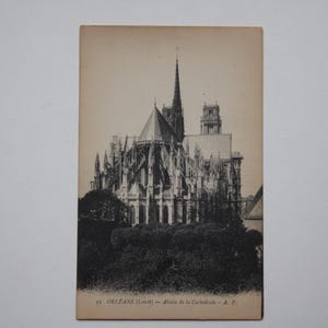 May include: A vintage sepia postcard depicting a detailed architectural drawing of a cathedral. The postcard shows the cathedral's intricate facade, tall spire, and surrounding trees. Text at the bottom reads "ORLEANS (Loiret) - Abside de la Cathédrale - A.P."