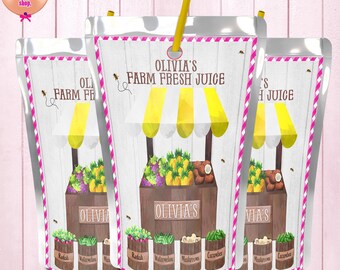 May include: Three juice pouches with a farm stand design. Each pouch features a wooden stand with yellow and white striped awning, selling fruits and vegetables. The text "OLIVIA'S FARM FRESH JUICE" is displayed. The bottom of the pouches display the names of the fruits and vegetables.