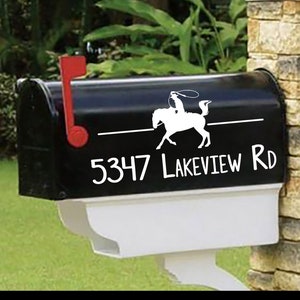 May include: Black mailbox with a white silhouette of a cowboy riding a horse and the address 5347 Lakeview Rd.