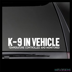 May include: White decal sticker with the text "K-9 in Vehicle" and "Temperature Controlled and Monitored" on a black car window.