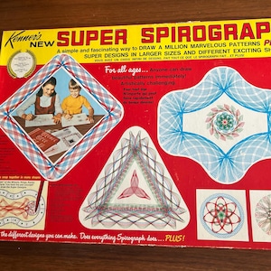 May include: Vintage Kenner's Super Spirograph box, red with yellow and blue accents. The box features illustrations of Spirograph designs and children drawing. Text includes "A simple and fascinating way to draw a million marvelous patterns plus."