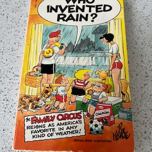 May include: A vintage paperback book titled "Who Invented Rain?" featuring a colorful illustration of The Family Circus characters. The cover has a yellow border and the text "The Family Circus reigns as America's favorite in any kind of weather!"