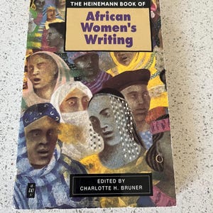 May include: A paperback book titled The Heinemann Book of African Women's Writing, edited by Charlotte H. Bruner. The cover features a colorful collage of painted portraits of various individuals in diverse headwear and clothing styles.