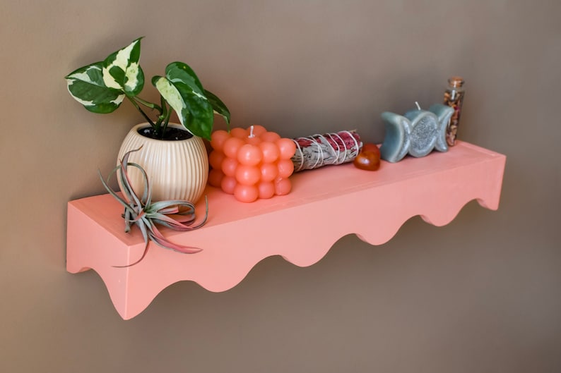 Peut inclure: Une &eacute;tag&egrave;re rose &agrave; bords festonn&eacute;s avec une plante en pot, un b&acirc;tonnet de sauge blanche, un cristal rouge, une bougie &agrave; bulles et une bougie triple lune grise.