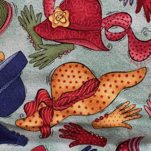 May include: Fabric with a repeating pattern of hats and gloves in various colors. The hats are red and yellow with polka dots and floral accents. The gloves are red, green, and blue. The background is a light green color.