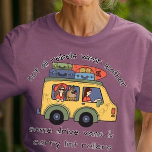 May include: A purple t-shirt with the text "not all rebels wear leather, some drive vans & carry lint rollers." The graphic shows a yellow van with passengers and luggage on top.