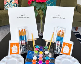 May include: A painting kit featuring two 9 x 12 inch stretched canvases on wooden easels, two sets of ten paintbrushes, two white plastic palettes, two disposable aprons, two yellow pencils, and a set of acrylic paints in small pots.
