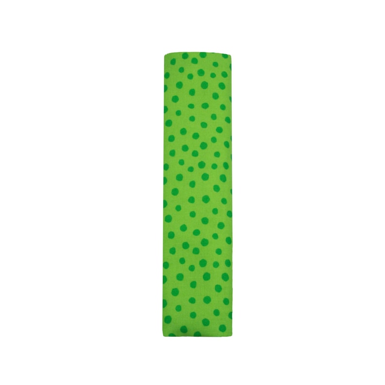 Puede incluir: Una muestra de tela rectangular que presenta un fondo verde lima vibrante cubierto con un patr&oacute;n de peque&ntilde;os puntos de color verde oscuro de forma irregular, dispersos por toda la superficie del material en una disposici&oacute;n org&aacute;nica y no uniforme.