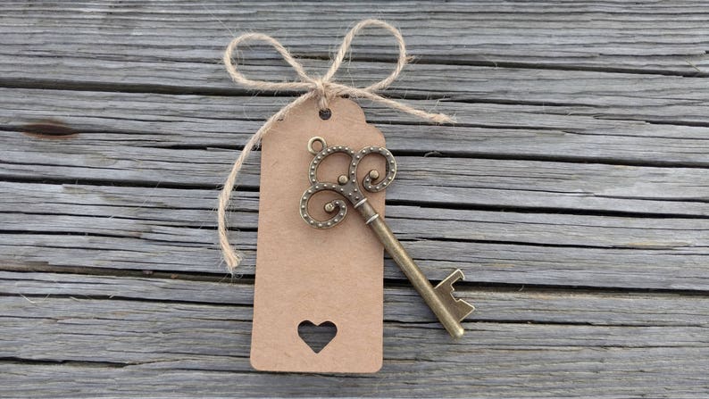 May include: A brown paper tag with a heart cut-out tied with twine and a vintage-style key bottle opener attached.