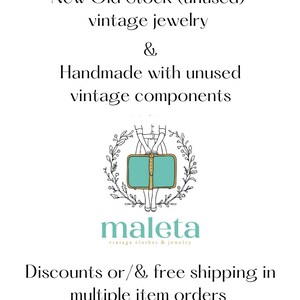 May include: A logo for a shop called "maleta" that sells vintage clothes and jewelry. The logo features a woman holding a suitcase with a green background and a gold trim. The text "maleta" is written in a cursive font below the image. The text "vintage clothes & jewelry" is written in a smaller font below the shop name.