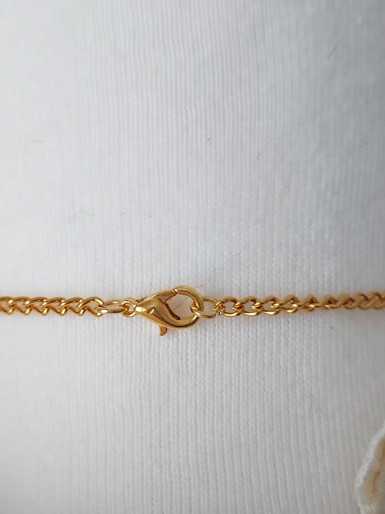 May include: Gold chain necklace with a lobster clasp closure.