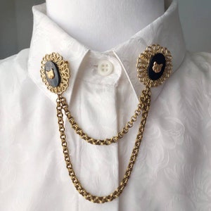 A marte old gold tone collar chain made with unused vintage parts: with two decorative circular filigree featuring black Shell with a brass miniature Cat face stamping on each. They have two sturdy chains linked to each filigree.