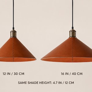 May include: Two conical pendant lights with brown leather shades and visible stitching, suspended by black cords from metallic fixtures. The left light measures 12 inches wide, the right 16 inches wide, and both have a shade height of 4.7 inches.