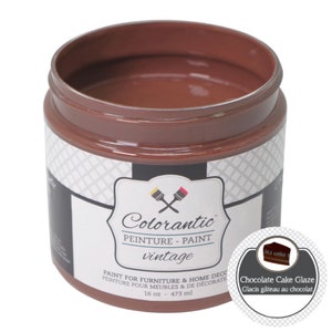 Op de afbeelding: Een pot van 473 ml Colorantic vintage verf in Chocolade Cake Glaze. De pot is bruin met een wit etiket en een zwart-wit geruit patroon aan de zijkant. Het etiket heeft het Colorantic logo en de tekst "Chocolade Cake Glaze" in een witte cirkel met een bruine rand.