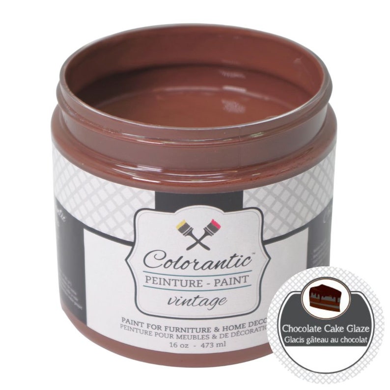 Op de afbeelding: Een pot van 473 ml Colorantic vintage verf in Chocolade Cake Glaze. De pot is bruin met een wit etiket en een zwart-wit geruit patroon aan de zijkant. Het etiket heeft het Colorantic logo en de tekst "Chocolade Cake Glaze" in een witte cirkel met een bruine rand.