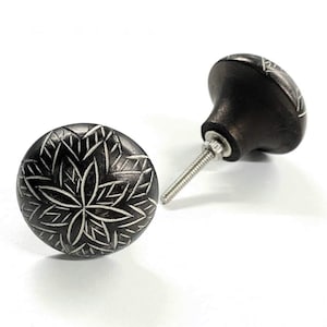Peut inclure: Deux boutons de cabinet en céramique noire avec un motif floral argenté. Les boutons ont une base ronde et une tige à visser.