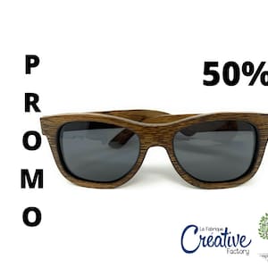 Peut inclure: Lunettes de soleil en bois avec des verres foncés et une finition en bois brun. Les lunettes de soleil sont à 50% de réduction. Le texte "PROMO" est sur le côté gauche de l'image. Le texte "La Fabrique Creative Factory" est sur le côté inférieur droit de l'image.