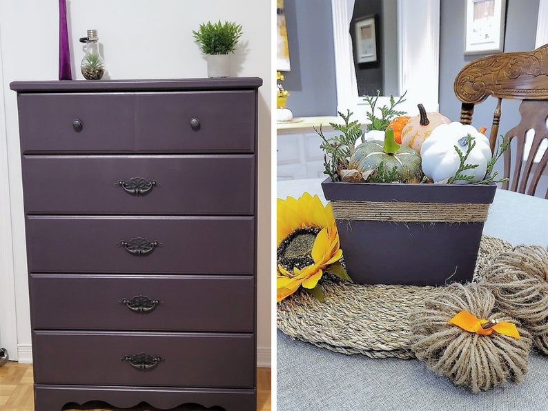 May include: A five-drawer chest of drawers painted in a deep purple colour with black drawer pulls. The chest of drawers has a slightly curved bottom edge and sits on a wooden floor.