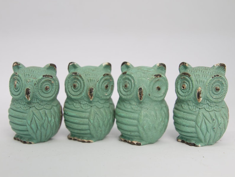 May include: Four small, teal-colored owl figurines. Each owl has a detailed design with raised eyes and feathers.