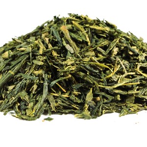 May include: A close-up of a pile of loose leaf green tea. The tea leaves are a vibrant green color and have a slightly yellow hue.