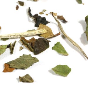 May include: Loose leaf white tea with green and brown leaves and white tea stems.
