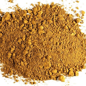 May include: A close-up of a pile of loose, brown, and yellow ground turmeric powder.