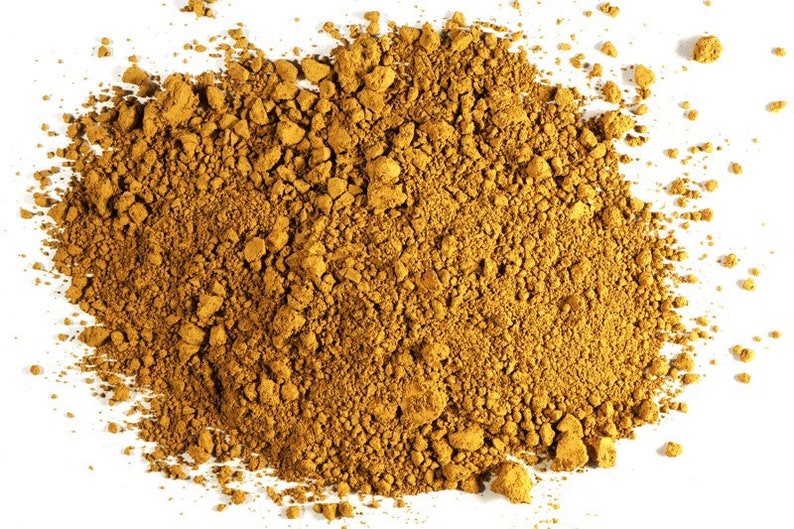 May include: A close-up of a pile of loose, brown, and yellow ground turmeric powder.