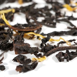May include: Close-up of black tea leaves and dried orange peel, a blend for a citrusy tea.