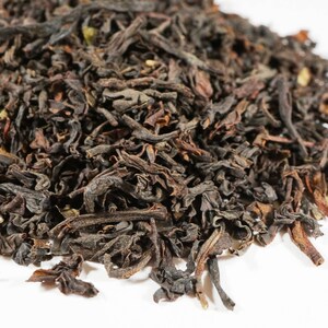 May include: Loose black tea leaves, dried and ready for brewing. The leaves are dark brown and have a slightly curled shape.