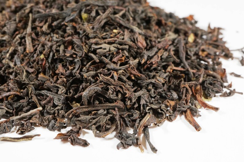 May include: Loose black tea leaves, dried and ready for brewing. The leaves are dark brown and have a slightly curled shape.