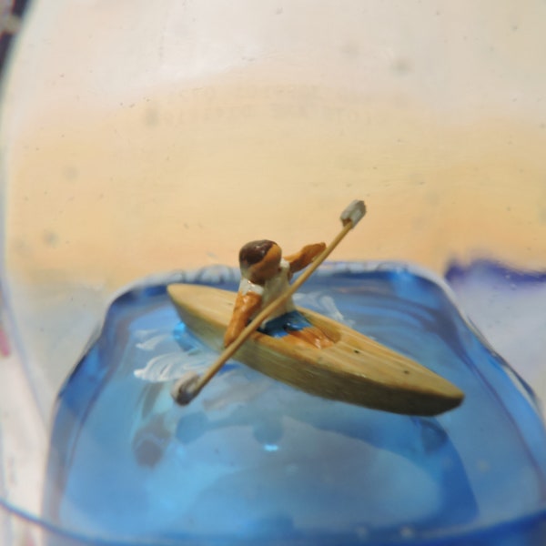 Kayak in a bottle, paddling on blue water