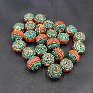 May include: A collection of round beads with a turquoise and orange design. The beads are made of wood and have a floral pattern.